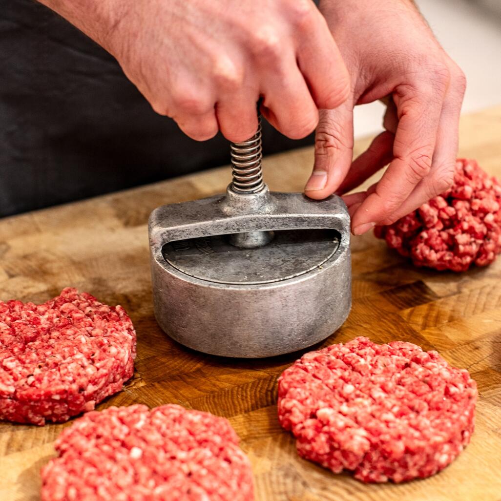 steak burger patty handpressed on wood board