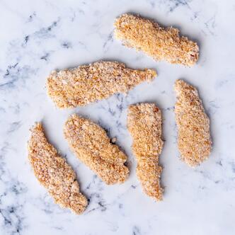 crumbled chicken goujons on marble background 