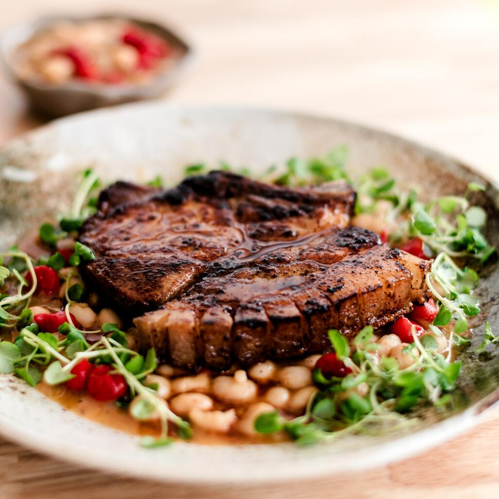 cooked pork chop with beans and chilli butter