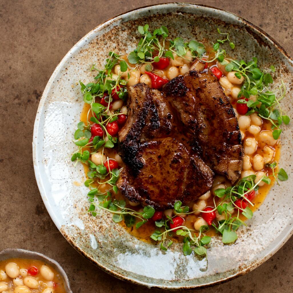 cooked pork chop with beans and chilli butter