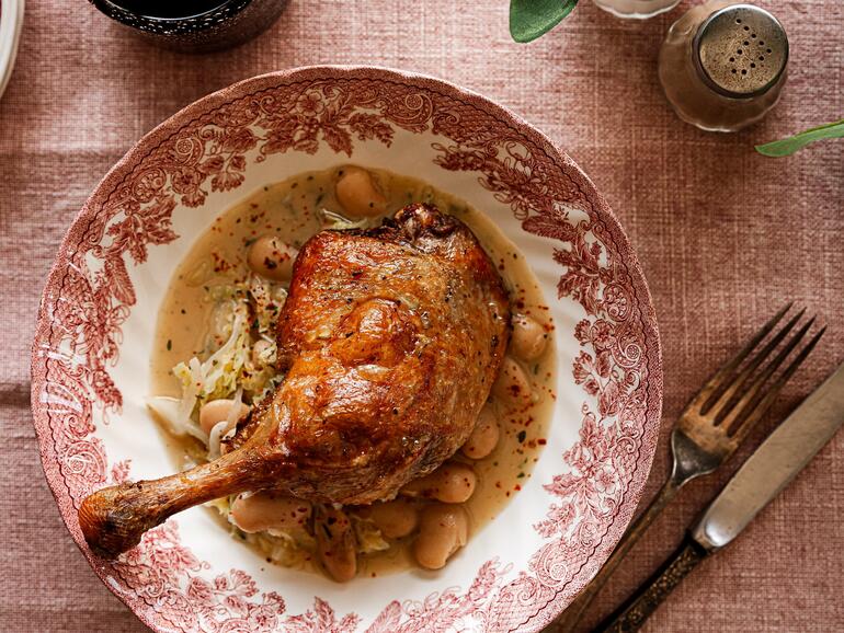 Photograph of How to cook Duck Confit with butter beans & savoy cabbage