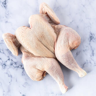 spatchcock chicken on marble background