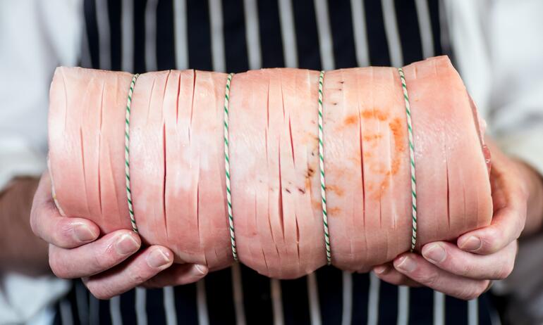 raw porchetta in hands