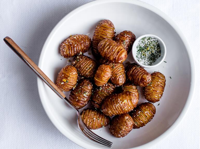 cooked hasselback potatoes with schmaltz and rosemary