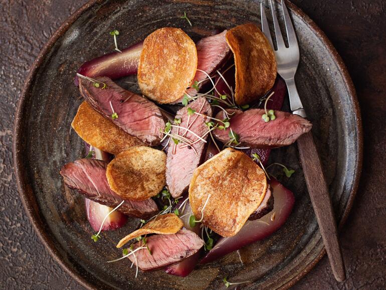 wild venison haunch steak with poached pears in red wine cooked