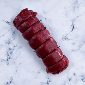 rolled saddle of venison on marble background