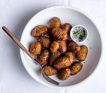 cooked hasselback potatoes with schmaltz and rosemary