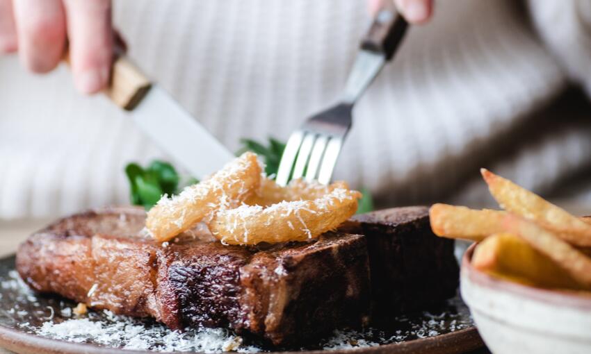 beef t bone steak with homemade chips and onion rings cooked