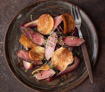 wild venison haunch steak with poached pears in red wine cooked