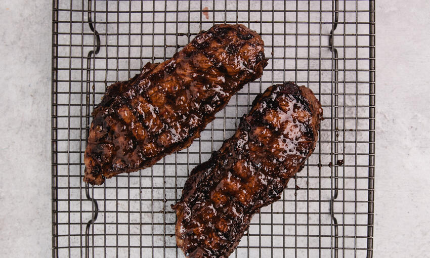 cooked steak on resting board