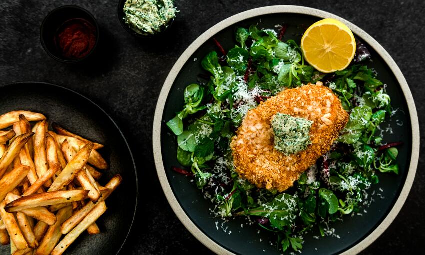 breaded pork cutlet with herb butter and chips