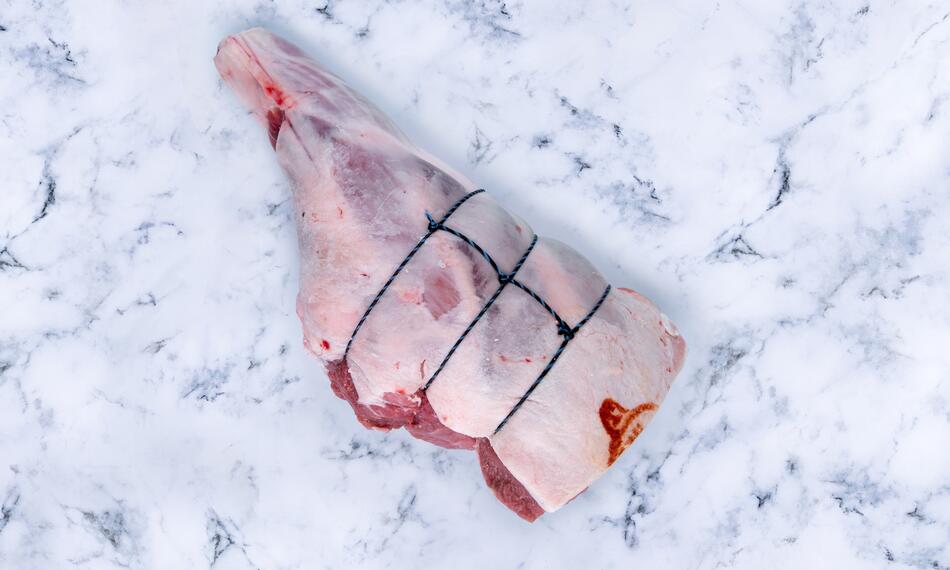 lamb leg raw on marble 