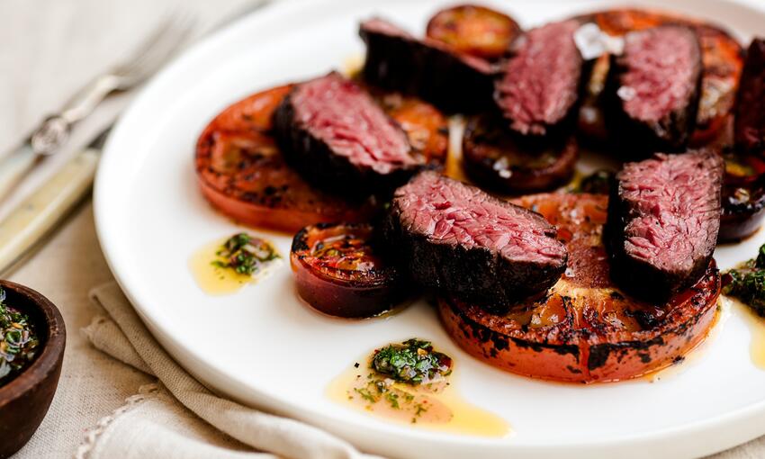 steak cooked with burnt tomatoes and chimichurri sauce 